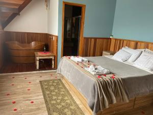 1 dormitorio con 1 cama grande y suelo de madera en Bela Vista Chalé en Campos do Jordão