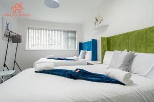 two beds in a room with white walls at Spacious 2 bedroom-Birmingham/sleeps 8/freeparking in Birmingham