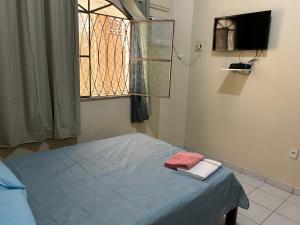 a bedroom with a bed with a window and a television at Apto próximo à Polícia Federal in Manaus