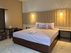 ein Hotelzimmer mit einem Bett mit einem Handtuch darauf in der Unterkunft 24 Sleep Resort Khlong Luang Hospital in Khlong Luang