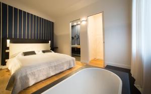 TB-One bedroom luxury apartment in the fashion district في فلورنسا: غرفة نوم بسرير ابيض وحوض استحمام
