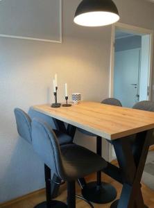 a dining room table with two candles and chairs at Design Apartment im Zentrum in Kahl am Main