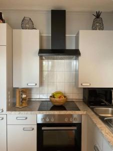 a kitchen with a bowl of fruit on the stove at Design Apartment im Zentrum in Kahl am Main