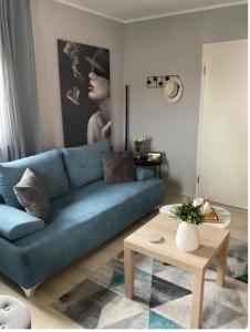 a living room with a blue couch and a table at Design Apartment im Zentrum in Kahl am Main