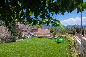 a garden with lawn chairs and a stone wall at Villa Salis in Gonia