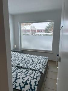 um quarto com uma cama e uma grande janela em Ferienwohnung am Ostseeküstenradweg em Stralsund