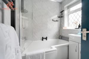 a white bathroom with a tub and a sink at Spacious 2 bedroom-Birmingham/sleeps 8/freeparking in Birmingham