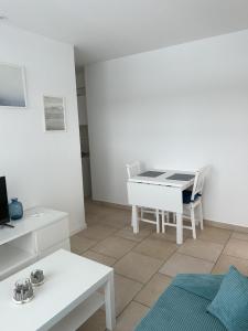 a living room with a white table and chairs at Ferienwohnung am Ostseeküstenradweg in Stralsund