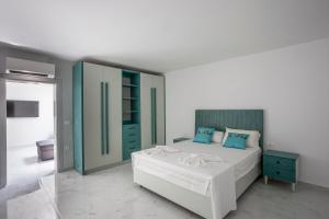 una camera da letto con un grande letto bianco e armadi blu di Megan Luxury villa with private pool a Pefkohori