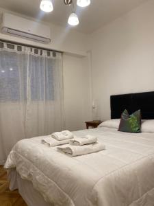 RECOLETA DEPARTAMENTO في بوينس آيرس: غرفة نوم مع منشفتين على سرير أبيض