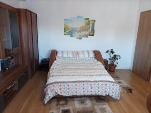 a bedroom with a bed with a blanket on it at Apartament Alex in Alba Iulia