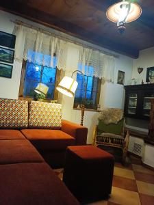 a living room with a couch and some windows at Chalet Horní Orlice in Červená Voda