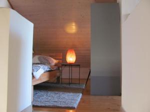 um quarto com uma cama e um candeeiro sobre uma mesa em #4 Dachstudiozimmer mit 2 Betten und Balkon mit WG Bad Airport nah freies W-Lan em Trunkelsberg