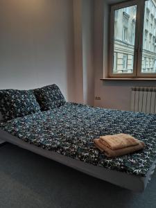 a bed in a bedroom with a pillow on it at Rooms in the Centrum in Warsaw