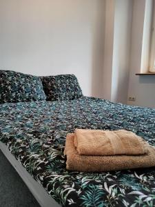 a bedroom with a bed with a green blanket and pillows at Rooms in the Centrum in Warsaw