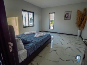 a bedroom with a bed and two windows at Luxury Sky Residence Penthouse in Paramaribo
