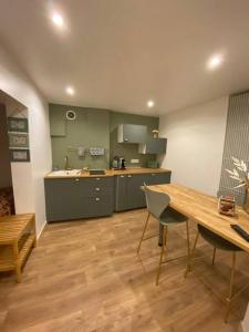 a kitchen with a wooden table and a wooden floor at LA MAISON D’ANTOINE 1 in Chamalières