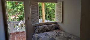 ein Zimmer mit zwei Fenstern und einem Bett davor in der Unterkunft O melhor lugar pra família, em Tamandaré in Tamandaré + 9 Fotos