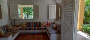 ein Wohnzimmer mit einer Couch und zwei Fenstern in der Unterkunft O melhor lugar pra família, em Tamandaré in Tamandaré