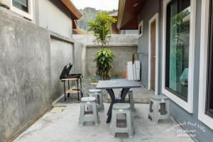 a table and stools sitting outside of a house at Sriphakdi Pool Villa Aonang Krabi in Ao Nang 