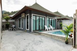 a house with a swimming pool in front of it at Sriphakdi Pool Villa Aonang Krabi in Ao Nang 