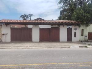 uma casa com duas portas de garagem e uma rua em Casa Cardoso em Bertioga