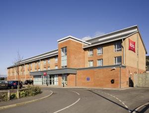 a large red brick building with a sign on it at ibis Swansea in Swansea