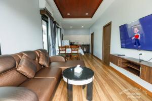 a living room with a couch and a flat screen tv at Sriphakdi Pool Villa Aonang Krabi in Ao Nang 