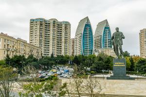 a statue of a man in a city with tall buildings at SEA VIEW HOTEL APART in Baku