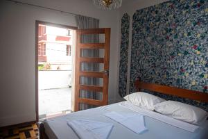 um quarto com uma cama e uma porta com uma janela em Hotel pousada Krone Praia de Iracema Fortaleza em Fortaleza