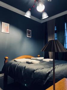 a bedroom with a bed with blue walls and a lamp at Central Apartment Black Cat in Karlovo
