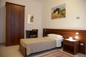 Polesine Camerini的住宿－Agriturismo La Violetta，一间卧室配有一张床和一个木制床头板