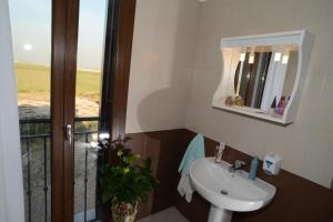 a bathroom with a sink and a mirror and a window at Agriturismo La Violetta in Polesine Camerini
