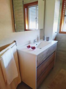 a bathroom with a white sink and a mirror at Casa da Carlota in Cinfães