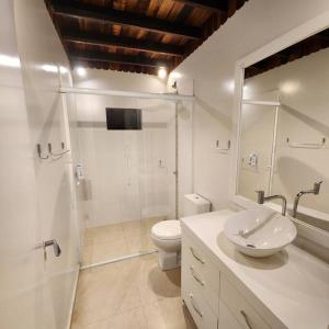 La salle de bains blanche est pourvue de toilettes et d'un lavabo. dans l'établissement Refúgio dos Passarinhos, à Taió