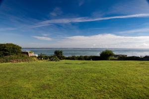 a field of green grass with the ocean in the background at Fantastic sea views and amazing coastal scenery in Yarmouth