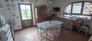eine Küche mit einem weißen Tisch und einem Fenster in der Unterkunft I Glicini Appartamento in Castagneto Carducci