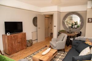 a living room with a couch and a tv at No.3 The Old Coach House in Blockley