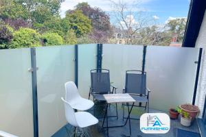 two chairs and a table on a balcony at Penthouse - Central - Parking in Harrogate