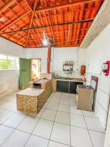 Il comprend une grande cuisine équipée d'une cuisinière et d'un réfrigérateur. dans l'établissement Ótima casa no centro de Carrancas, à Carrancas