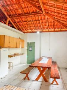 een keuken met een houten tafel in een kamer bij Ótima casa no centro de Carrancas in Carrancas