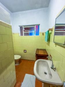 uma casa de banho com um lavatório e um WC em Ótima casa no centro de Carrancas em Carrancas