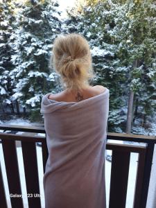 a woman standing on a balcony looking out the window at FOX boutique apartment Borovets Gardens in Borovets