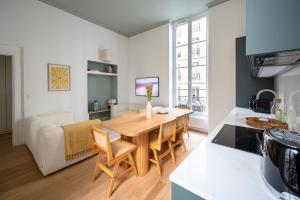 a kitchen and living room with a table and a couch at Noble Suites in Paris