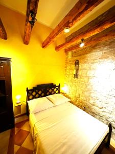 una camera con letto e parete in pietra di Villa Gabine a Kaštela (Castelli)