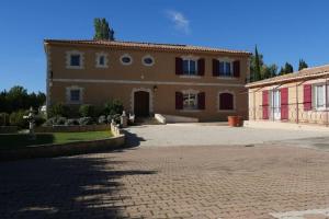 a large house with a brick driveway in front of it at Luciole des Alpilles in Mouriès