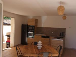 a kitchen with a wooden table and a dining room at Luciole des Alpilles in Mouriès