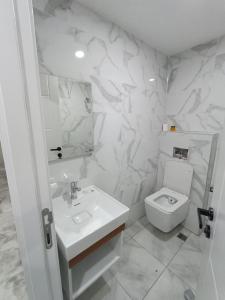 a white bathroom with a toilet and a sink at dara otel in Midyat