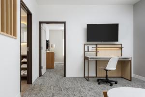 an office with a desk and a tv on a wall at TownePlace Suites by Marriott Chattanooga South, East Ridge in Chattanooga