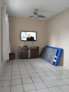 sala de estar con TV de pantalla plana en la pared en Casa de praia para temporada espaço inteiro Putiri ES, en Santa Cruz